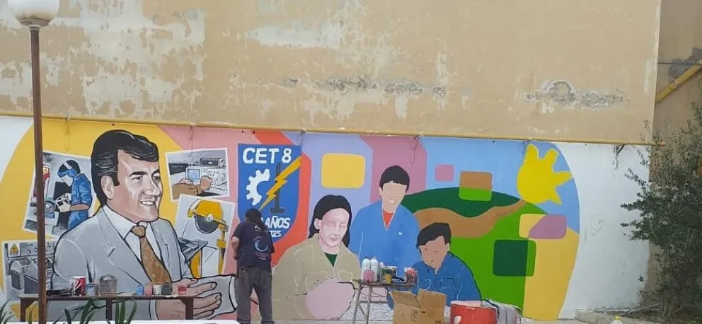 El muralista roquense Chelo Candia pintó junto a estudiantes un mural de ocho metros que homenajea a Carlos Isaguirre y celebra los 50 años del CET 8 de Allen. Foto (gentileza)