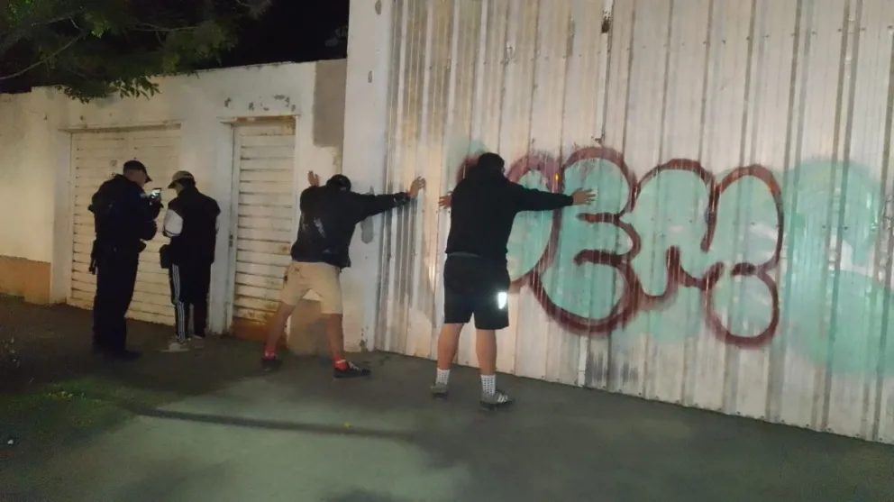 Efectivos policiales sorprendieron a tres jóvenes mientras realizaban pintadas con aerosol sobre el portón de un local céntrico. Foto: Policía de Río Negro
