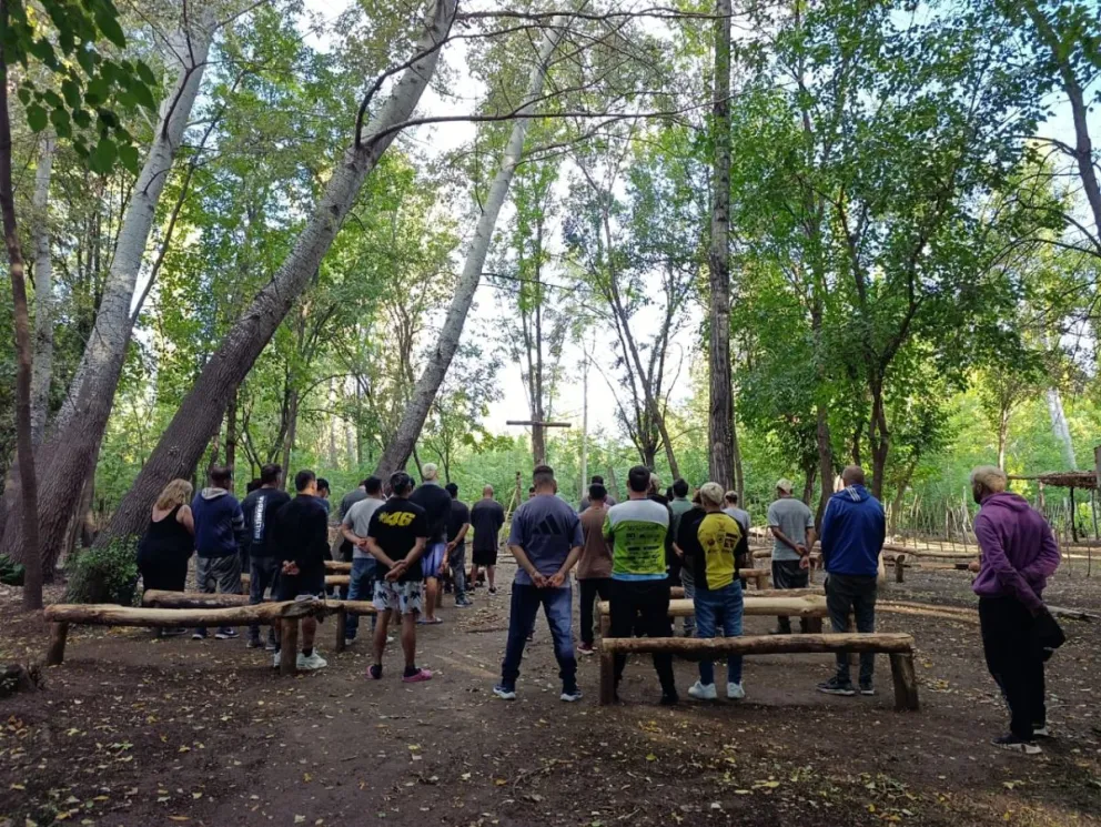 Cada tarde, los hombres que viven en la granja se reúnen frente a la cruz para cerrar el día. La oración es parte del proceso que atraviesan. Foto: Tania Domenicucci
