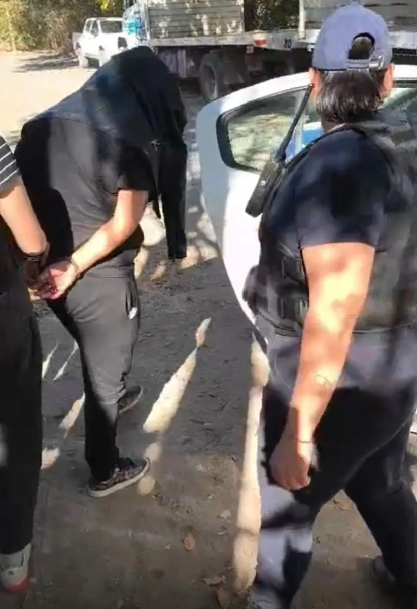 Uno de los sospechosos detenidos fue trasladado por personal policial tras los allanamientos realizados en Allen. Foto: gentileza