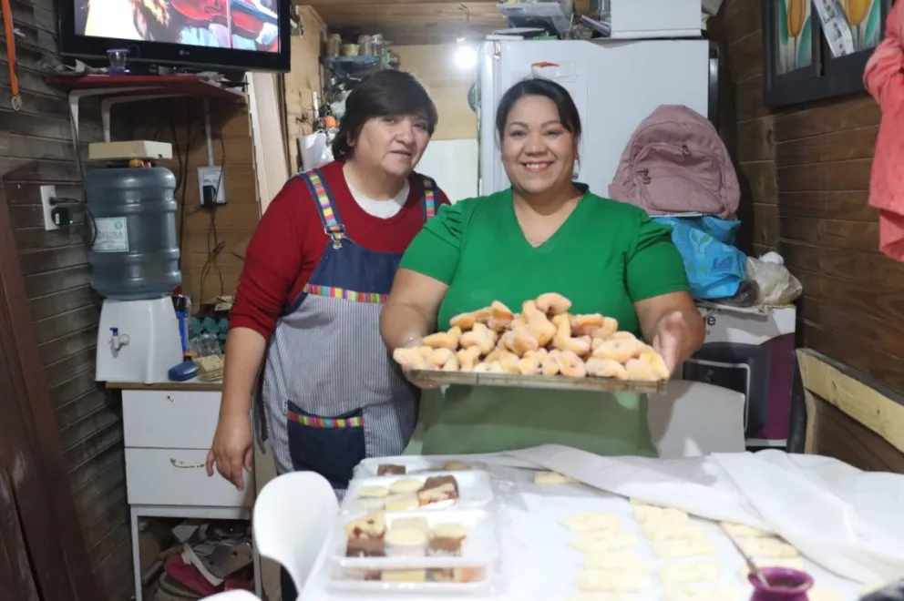Gabriela sostiene la bandeja junto a Patricia y se preparan para recibir a las familias. Fotos Tania Domenicucci