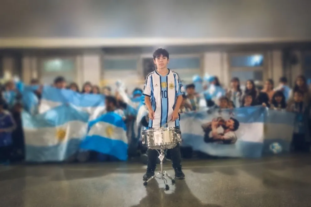 Un estudiante marca el ritmo con el redoblante mientras sus compañeros interpretan la canción que crearon para alentar a la Selección Argentina en el Mundial. Captura de video.