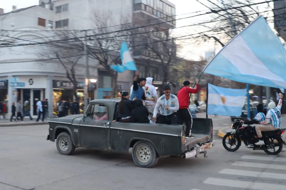 Desde todos los puntos de la ciudad llegan a Avenida Roca y Tucumán vecinos con banderas, gorros y camisetas de la Selección. (Foto: Tania Domenicucci. ANR)