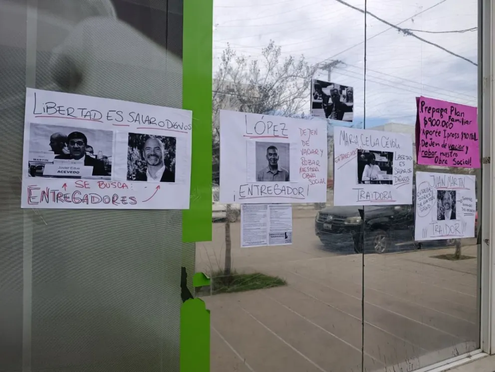 epigrafe fotos e tania

Afiches con críticas a legisladores fueron colocados en el frente de la sede del Ipross en Roca durante la protesta de este viernes. Foto: Tania Domenicucci.
