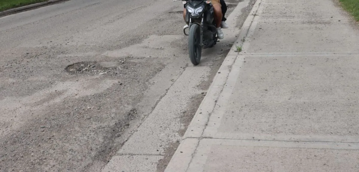 Motocilistas buscan evitar los pozos al transitar por Vitterbori. Foto: Tania Domenicucci